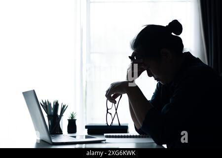 Geschäftsfrau sah sich im Büro mit schwierigen Problemen konfrontiert, indem sie durch den Stress am Arbeitsplatz ging und ihren Computer benutzte, um Lösungen zu finden, die unter Gefühlen von Depressionen lagen. Prob Stockfoto