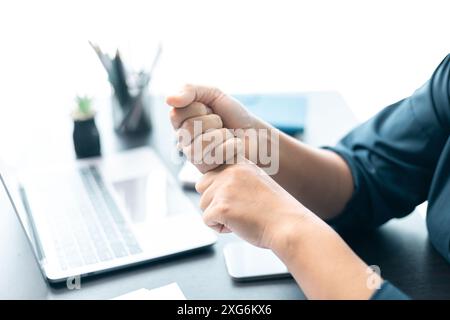 Die Person erlitt Schmerzen und Entzündungen im Handgelenk, wahrscheinlich aufgrund einer Verletzung oder Arthritis, die die Hand- und Fingermuskeln betraf, was zu Bedenken ab führte Stockfoto