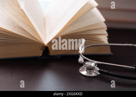 Umgeben von medizinischen Büchern und ausgestattet mit Stethoskop, verkörpert jahrelange Ausbildung und Engagement für die Bereitstellung qualitativ hochwertiger Gesundheitsversorgung. Konzept von St Stockfoto