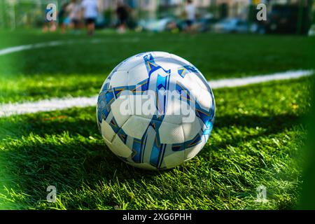 Fußball mit blauen Linien auf dem grünen Kunstrasenfeld Stockfoto