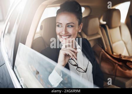 Geschäftsfrau, lächeln und reisen Sie zur Arbeit im Auto für Luxustransporte, Pendeln und Chauffeur mit Ideen. Berater, glücklich und fährt mit in die Stadt Stockfoto