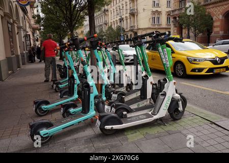 Elektroroller aus dem Lime- und Tier-Sharing-Programm parkten auf dem Bürgersteig in Budapest, Ungarn Stockfoto