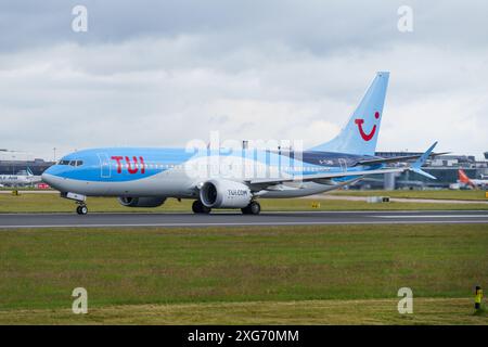 Die Boeing 737 von TUI Airways stand unter dunklem Himmel auf der Landebahn 2 am Flughafen Manchester Stockfoto