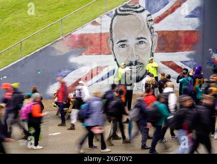 Die Zuschauer passieren ein Wandbild von Lewis Hamilton vor dem Rennen auf dem Silverstone Circuit in Northamptonshire. Bilddatum: Sonntag, 7. Juli 2024. Stockfoto