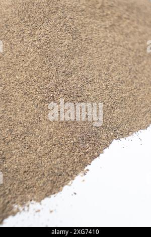Verschüttetes gemahlenes Gewürz mit schwarzem Pfeffer auf weißem Hintergrund. Stockfoto