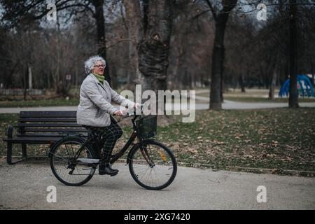 Aktive Seniorin, die eine Fahrradtour im Park macht Stockfoto