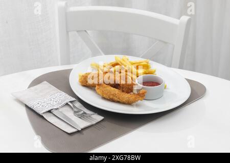 Frittierte Fischstäbchen mit Pommes frites. Fischfinger. Fischstäbchen mit frittierten Kartoffeln zum Verzehr. Auf hellem Hintergrund in einem Restaurant Stockfoto