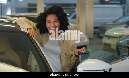 Glücklicher Kunde Kunde Afroamerikanerin Geschäftsfrau Mädchen, das neues Auto kauft Genießen Sie Luxuskauf im Autohändler weibliche Besitzer kaufen Mietfahrzeug Stockfoto