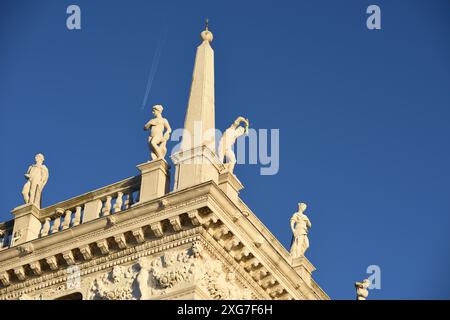 Mit Blick auf die Säulen des Löwen von St. Markus und St. Theodore und Statuen auf der Balustrade, Biblioteca Nazionale Marciana vor einem blauen Himmel Stockfoto