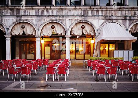 Vor Sonnenaufgang, rote Kaffeestühle auf der Piazza San Marco, Bögen der Arkade Procuratie Vecchie, keine Leute, keine Touristen Stockfoto