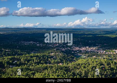 Blick auf das Dorf Tourves in Var, Südfrankreich, umgeben von Kiefernwäldern unter einem leicht bewölkten blauen Winterhimmel Stockfoto