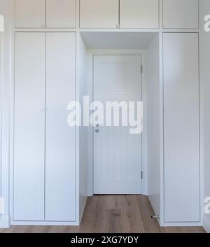 Moderne, moderne Schränke in weiß lackiertem MDF. Die Schränke sind in einem minimalistischen, einfachen Stil gestaltet. Mit gewölbtem Dach. Stockfoto