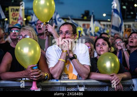 Ein Demonstrant hält sein Gesicht, während er neben Demonstranten mit gelben Ballonen eine Rede für die Freilassung der Geiseln während der Demonstration anhört. Über 100.000 Israelis demonstrierten in Kaplan mit Geiselfamilien gegen Premierminister Benjamin Netanjahu und forderten einen sofortigen Geiselvertrag und Waffenstillstand. Während der Kundgebung blockierten Demonstranten die Autobahn Ayalon und wurden von einer Wasserkanone der Polizei zerstreut. Stockfoto