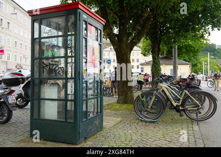 Salzburg, Österreich. 30. Juni 2024. Eine alte Telefonzelle auf einem Bürgersteig im Stadtzentrum Stockfoto