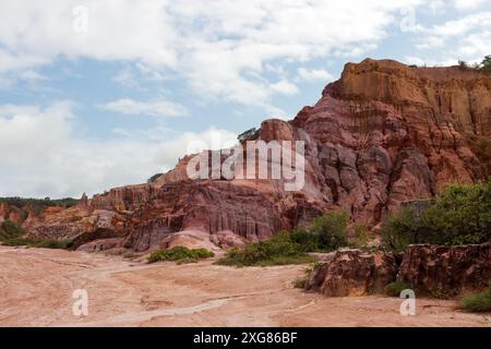 Ein malerischer Blick auf farbenfrohe Felsformationen unter einem teilweise bewölkten Himmel in einem Canyon. Stockfoto