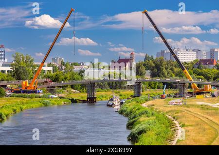 Blick auf den Bau einer neuen Fußgängerbrücke über den Fluss Warta in der Stadt Posen an einem sonnigen Tag, Polen Stockfoto