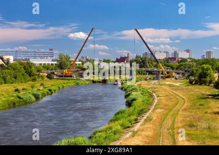 Blick auf den Bau einer neuen Fußgängerbrücke über den Fluss Warta in der Stadt Posen an einem sonnigen Tag, Polen Stockfoto