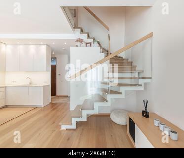 Küche und Wohnzimmer innen in neuem Luxus Haus mit offenem Konzept Grundriss. Mit Waschbecken, Hartholzfußboden und Treppe zum zweiten Stock. Breiter Winkel Stockfoto