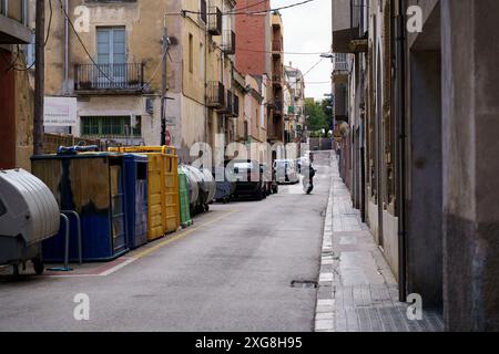 Figueres, Spanien - 14. Mai 2023: Dieses Bild zeigt eine enge Stadtstraße, die von geparkten Autos gesäumt ist und die städtische Staus und begrenzte Parkplätze darstellt Stockfoto