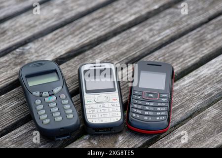 Alte Handys auf einem alten verwitterten Holztisch Stockfoto