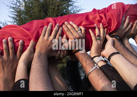 Obligatorischer Hinweis: Foto von Adil Abass/ZUMA Press Wire/Shutterstock (14576334d)Kashmiri schiitische Muslime, die während der Vorbereitungen am 1. Tag des Monats Muharram eine religiöse Flagge halten, was den Beginn von Ashura markiert, einer zehntägigen Gedenkzeit zum Märtyrertod des Propheten Muhammads Enkel Imam Hussain. Muharram Flaggenhisserei in Kaschmir, Indien, Srinagar, Jammu und Kaschmir - 07. Juli 2024 Stockfoto