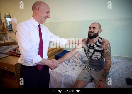 Odesa, Ukraine. Juli 2024. Der britische Verteidigungsminister John Healey, links, trifft sich am 7. Juli 2024 in Odesa, Ukraine, mit verwundeten Kriegern während eines Besuchs in einem Marinekrankenhaus mit dem ukrainischen Präsidenten Wolodymyr Zelenskyj. Healey versprach der Ukraine neue Unterstützung durch die neue Labour-Regierung im Vereinigten Königreich. Kredit: Ukrainischer Ratsvorsitz/Pressestelle Des Ukrainischen Präsidenten/Alamy Live News Stockfoto