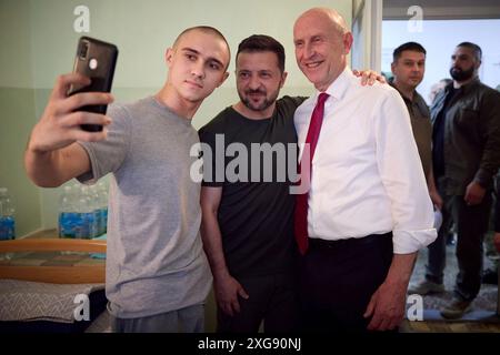 Odesa, Ukraine. Juli 2024. Der ukrainische Präsident Wolodymyr Zelenskyj, Zentrum, und der britische Verteidigungsminister John Healey, rechts, posierten für ein Selfie mit einem verwundeten Krieger während eines Besuchs in einem Marinekrankenhaus am 7. Juli 2024 in Odesa, Ukraine. Healey versprach der Ukraine neue Unterstützung durch die neue Labour-Regierung im Vereinigten Königreich. Kredit: Ukrainischer Ratsvorsitz/Pressestelle Des Ukrainischen Präsidenten/Alamy Live News Stockfoto