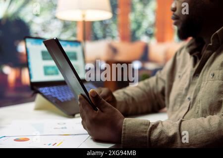 Geschäftsmann, der zu Hause recherchiert, um Gewinn und Ausgaben zu berechnen, arbeitet an der Bilanzbilanz für die Finanzplanung. Unternehmer, der einen Versicherungsplan für Expansion bereitstellt. Stockfoto