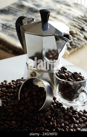 Italienische Mokkakanne (Caffettiera oder Macchinetta del Caffè), italienische Kaffeemaschine mit Kaffeebohnen im Hintergrund Stockfoto