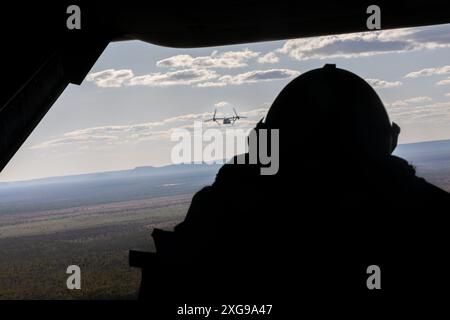 Spencer PerezDuran, ein MV-22B Osprey Crew Chief mit Marine Medium Tiltrotor Squadron 268 (verstärkt), Marine Rotational Force – Darwin 24.3, blickt aus dem Rücken eines MV-22B Osprey auf dem Weg zum Nackeroo Airfield, NT, Australien, 27. Juni 2024. MRF-D 24,3 ist Teil eines jährlichen sechsmonatigen Rotationseinsatzes zur Verbesserung der Interoperabilität mit der australischen Verteidigungsstreitkräfte und den Verbündeten und Partnern sowie zur Bereitstellung einer vorausschauenden Krisenreaktionstruppe im Indopazifik. PerezDuran stammt aus Colorado. (Foto des U.S. Marine Corps von CPL. MiGeL A. Reynosa) Stockfoto