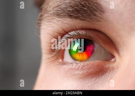 Das Auge des Mannes ist in Regenbogenfarben getönt, Nahaufnahme Stockfoto