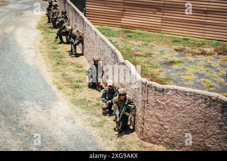 Die US-Marines, die der Bravo Company, dem Battalion Landing Team 1/5, der 15. Marine Expeditionary Unit und der Republik Korea Marines sind bereit, in ein Gebäude innerhalb des Infanterie-Tauchtrainers im Marine Corps Training Area Bellows, Waimanalo, Hawaii, zu ziehen, während der Übung Rim of the Pacific (RIMPAC) 2024, 3. Juli. 29 Nationen, 40 Überlandschiffe, drei U-Boote, 14 nationale Landstreitkräfte, mehr als 150 Flugzeuge und 25.000 Mitarbeiter nehmen vom 27. Juni bis 1. August an der RIMPAC Teil. RIMPAC, die weltweit größte internationale maritime Übung, bietet ein Uniq Stockfoto