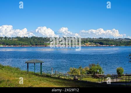 Blick über die Tacoma Narrows Strait vom Tacoma Narrows Park in Washington an einem sonnigen Nachmittag mit Mt. Rainier ist teilweise in der niedrigen Wolke sichtbar Stockfoto