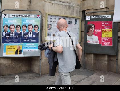 Paris, Frankreich. Juli 2024. Die Einwohner laufen während der letzten Runde der Parlamentswahlen in Paris, Frankreich, am Sonntag, den 7. Juli 2024 an Wahlkampfplakaten vorbei. Die Wahlen haben ein hängendes parlament ausgelöst, wobei eine linke Allianz unerwartet den Spitzenplatz vor der extremen Rechten einnahm und die französischen politischen Parteien vor die gewaltige Aufgabe gestellt wurden, eine Regierung zusammenzustellen. Foto: Maya Vidon-White/UPI Credit: UPI/Alamy Live News Stockfoto