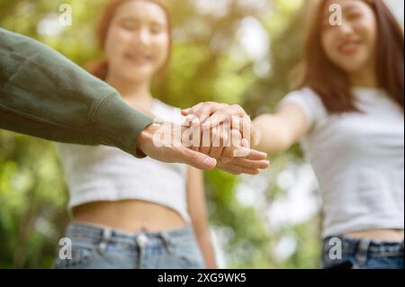 Ein Nahbild einer Gruppe von Freunden, die ihre Hände zusammenlegen, während sie in einem Park stehen. Teamarbeit, Freundschaft, Einheit, Aufmunterung, Ermutigung Stockfoto
