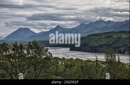 Bäume, Fluss und Berge an einem bewölkten Sommertag im Matanuska-Susitna Valley in Alaska bei Palmer. Stockfoto