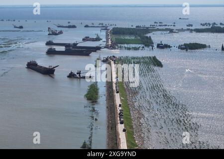 Peking, Chinas Provinz Hunan. Juli 2024. Ein Drohnenfoto zeigt Rettungskräfte, die am 7. Juli 2024 den Deichbruch des Dongting-Sees im Huarong County in der Provinz Hunan in Zentralchina blockieren. Nach der sofortigen Umsiedlung von rund 5.000 Einwohnern aus dem betroffenen Gebiet wurden dringende Maßnahmen zur Behebung des Verstoßes ergriffen. Quelle: Chen Zeguo/Xinhua/Alamy Live News Stockfoto