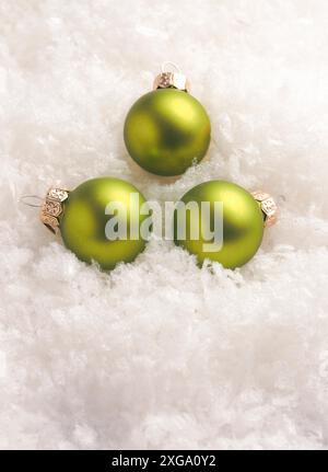Drei grüne Weihnachtskugeln im Schnee, Weihnachtskarte, saisonaler oder weihnachtlicher Hintergrund Stockfoto