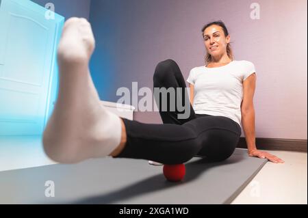 Junge attraktive Frau, die Übungen macht, Weitwinkelansicht von unten, Indoor-Workout zu Hause Stockfoto