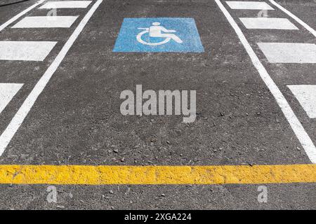 Rollstuhlparkplatz im Freien. Verkehrszeichen Behindertensymbol auf Asphalt gemalt Stockfoto