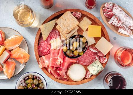 Wurst- und Käsebrett mit Wein, Flachbild-Schuss über dem Kopf. Italienische Antipasti oder spanische Tapas, von oben mit Oliven- und Lachsanwiches geschossen. Stockfoto
