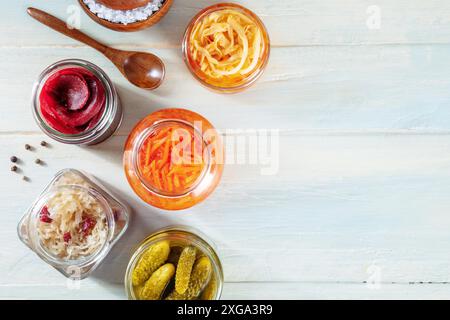 Fermentierte Lebensmittel. Gemüse aus der Dose. Eingelegte Karotten, Rüben, Sauerkohl und andere organische Konserven in Glasgläsern, oben flach auf einem rustikalen Schuss Stockfoto