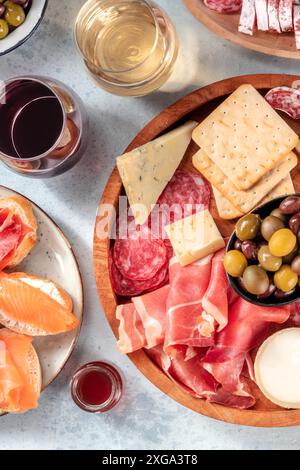 Italienische Antipasti oder spanische Tapas mit Wein. Gourmet-Wurstwaren und Käsebrett, von oben geschossen. Lachssandwiches, Salami, Parma-Marmelade, blau Stockfoto
