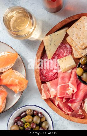 Wein und Antipasti. Lachs-Sandwiches, Wurstwaren und Käseplatte mit Oliven. Blauschimmelkäse, parmaschinken, Salami, von oben geschossen. Snacks für den Urlaub Stockfoto