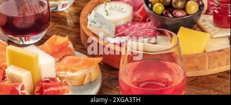 Panorama-Weinsnacks mit Weingläsern, Sandwiches und Käse- und Wurstplatte. Panorama-Banner für Gourmet-Vorspeisen für ein Restaurantmenü. Stockfoto