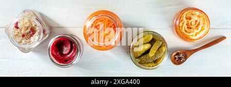 Panorama fermentierter Speisen. Gemüse aus der Dose. Gurken, Sauerkohl und andere biologische Konserven in Glasgläsern. Gesundes veganes Kochkonzept auf A Stockfoto