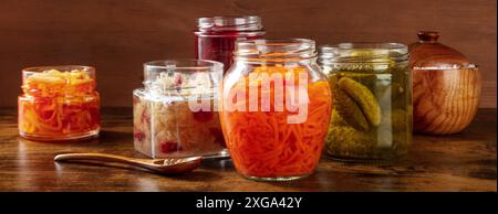 Fermentierte, probiotische Lebensmittel rustikales Panorama. Gemüsekonserven. Eingelegte Karotten, Sauerkraut, Gurken und andere Bio-Konfitüren in Gläsern Stockfoto