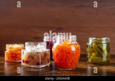 Fermentierte, probiotische Lebensmittel. Gemüse aus der Dose. Gurken, Sauerkraut und andere biologische Konserven in einmachgläsern. Gesundes veganes Kochen Hintergrund mit Stockfoto