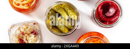 Fermentiertes Nahrungs-Panorama, aufgenommen von oben auf weißem Hintergrund. Gurken, Rote Beete, Sauerkraut und anderes probiotisches Gemüse in Glasgefäßen Stockfoto