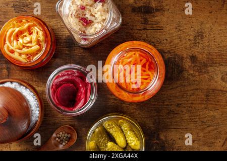 Fermentierte Lebensmittel. Gemüse aus der Dose. Eingelegte Karotten, Rüben, Sauerkohl und andere organische Konserven in Glasgläsern, oben flach in einer Dunkelheit Stockfoto